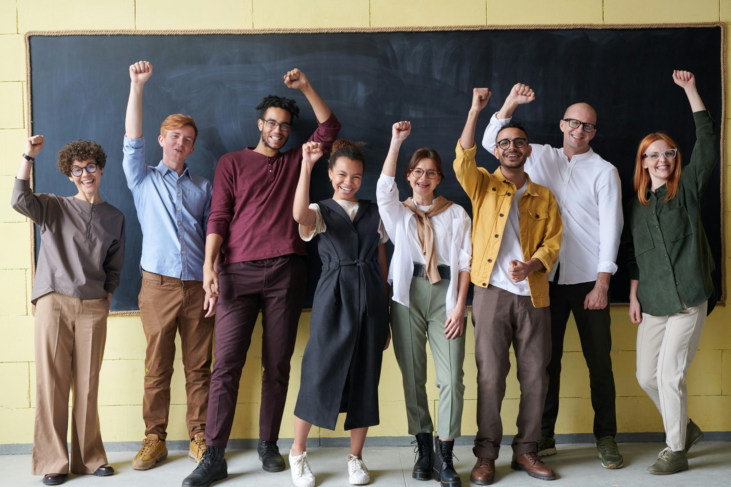 A group of people smiling and raising their arms